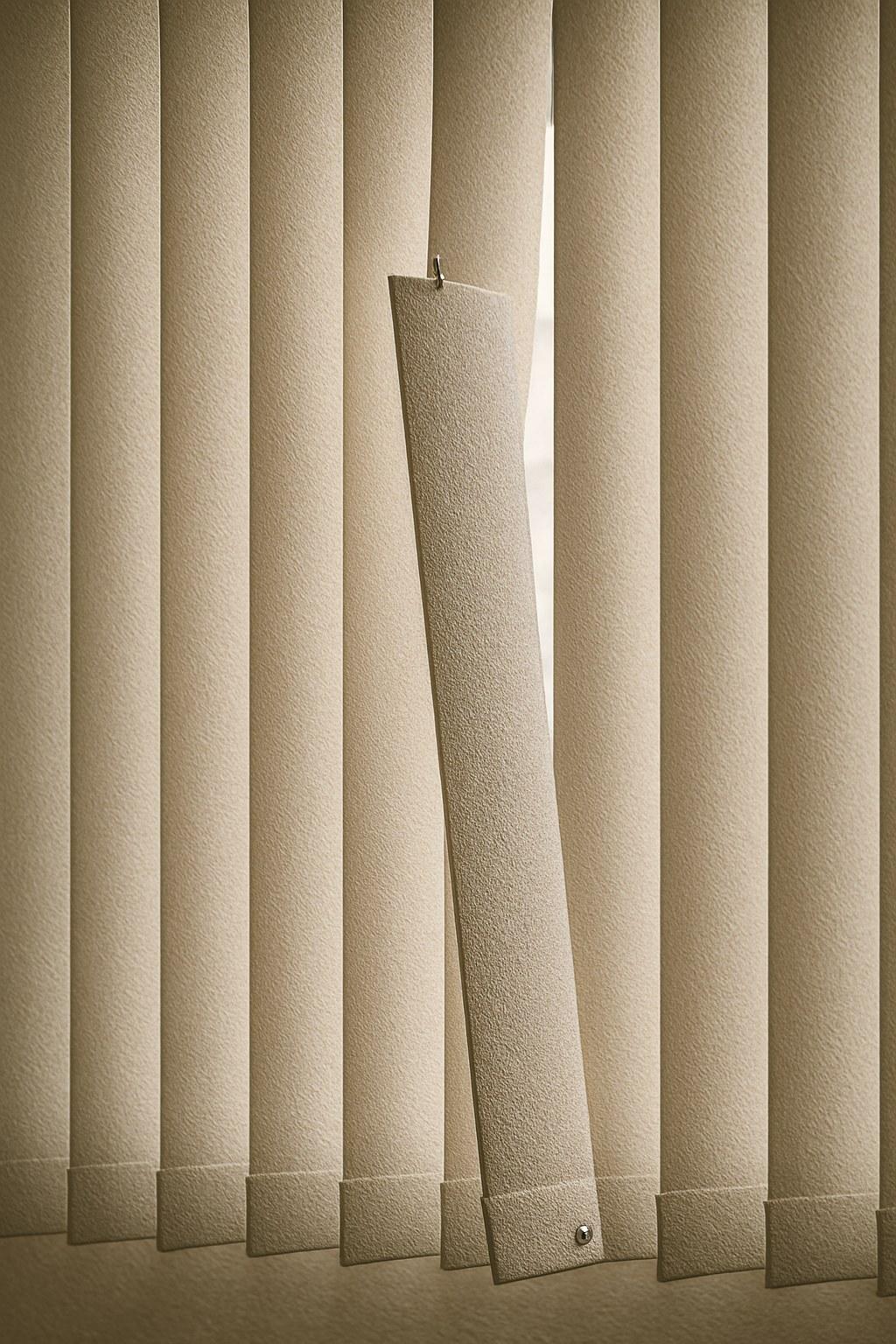 A single vertical blind panel hanging off its track.